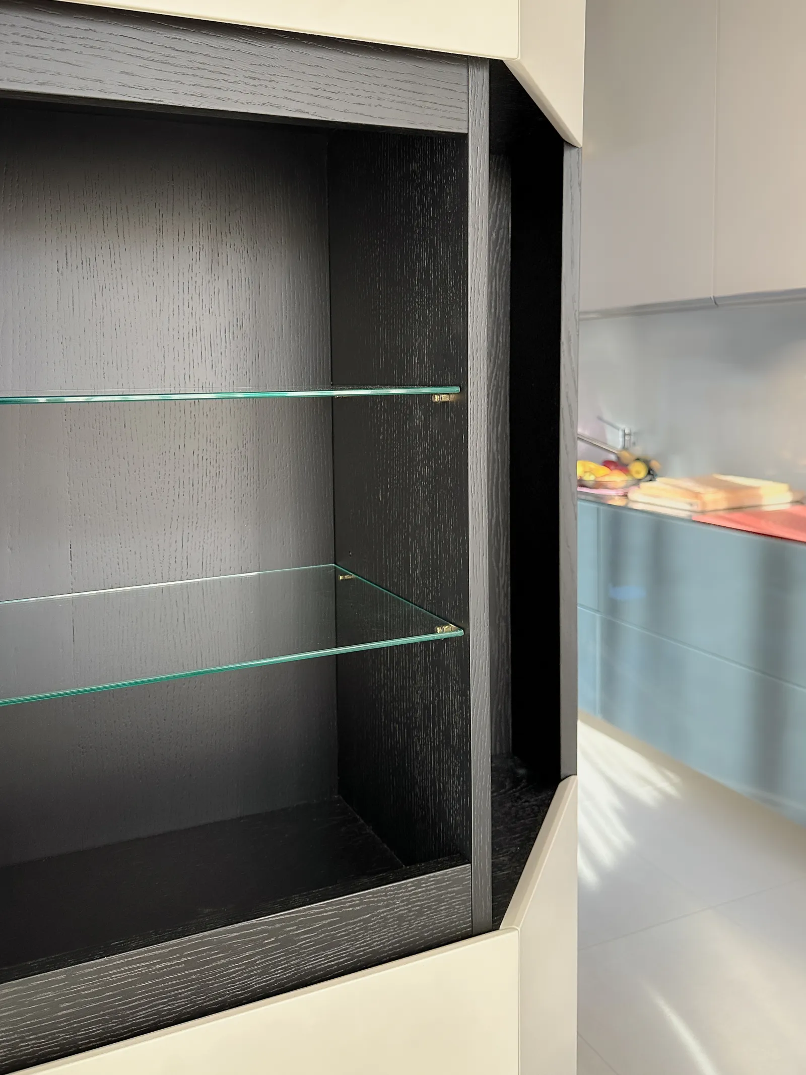 La colonna vetrina in rovere nero con i ripiani in vetro, aperta verso la cucina