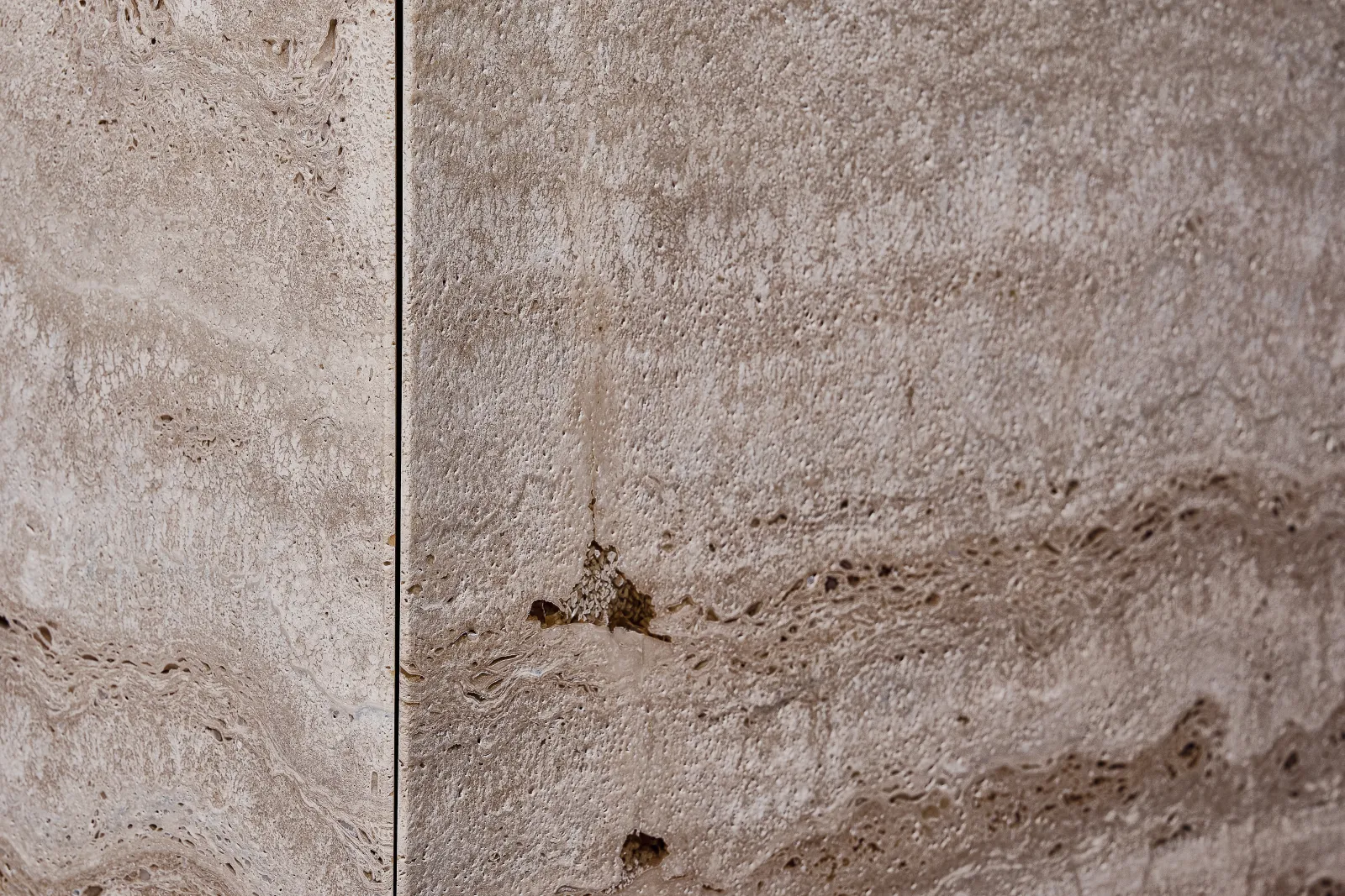 Le cavità naturali del travertino, riempite dalla resina trasparente senza essere nascoste