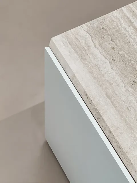 Il volume in travertino sopra l'anta bianca