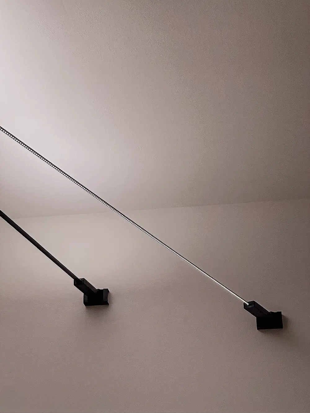 Una linea di luce continua attraversa un soffitto in penombra