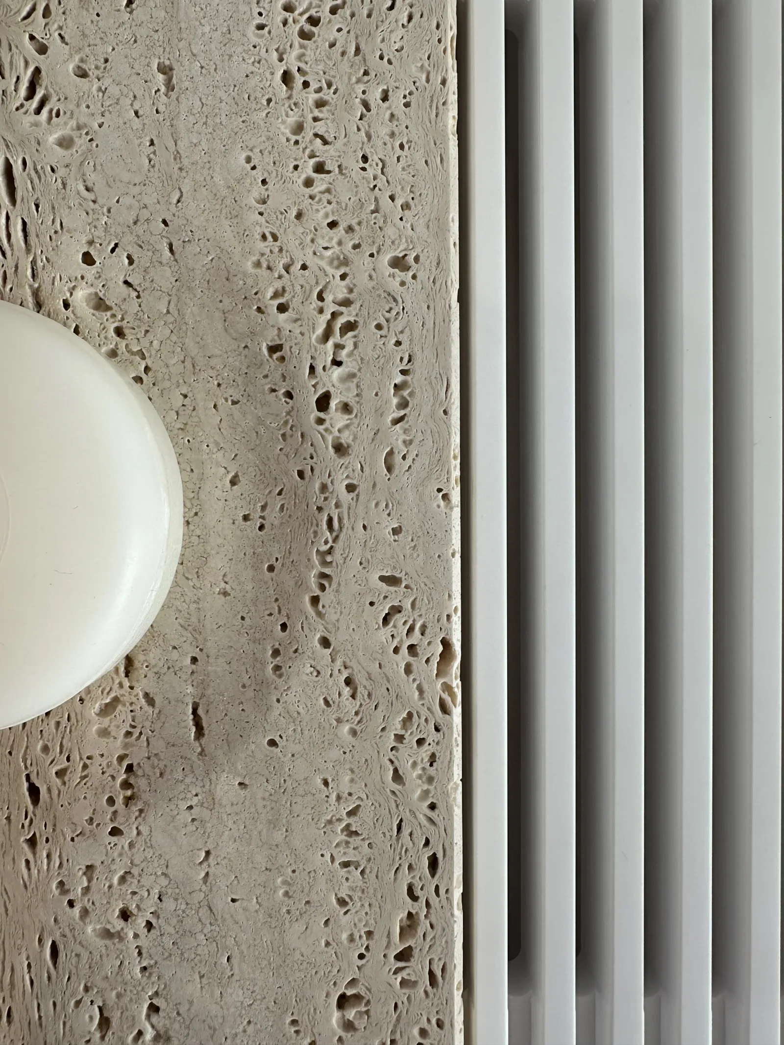 Travertino e ceramica nello showroom Origo, attraversati dalla luce naturale